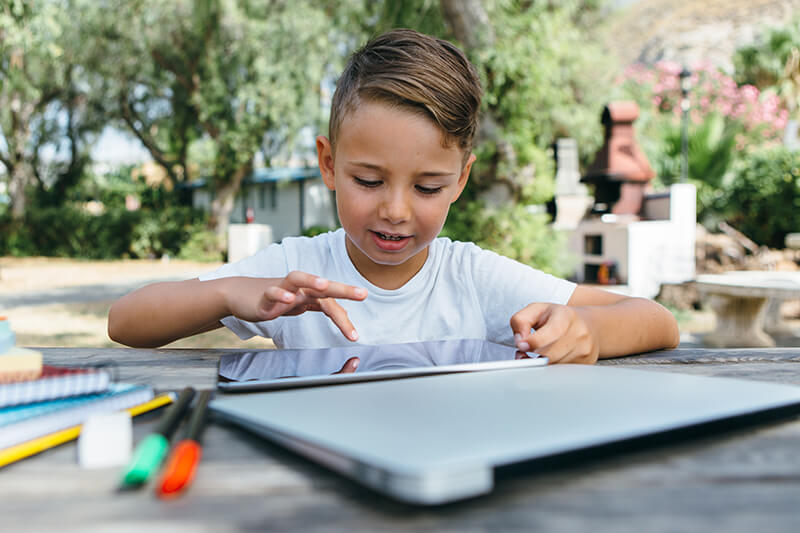 kid-with-tablet-studying-in-garden.jpg